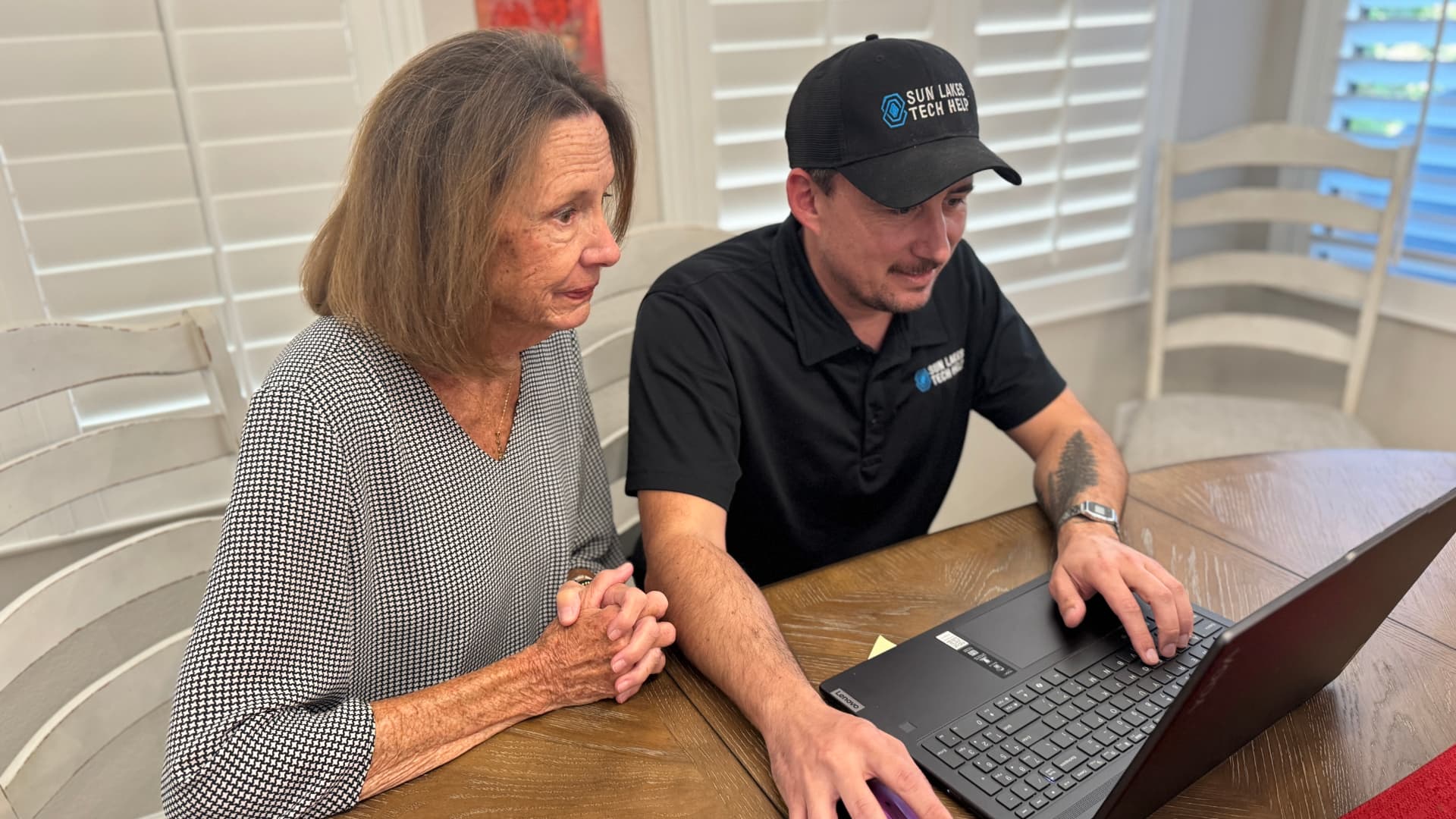 A Sun Lakes Tech Help technician patiently assisting a neighbor with her laptop at home